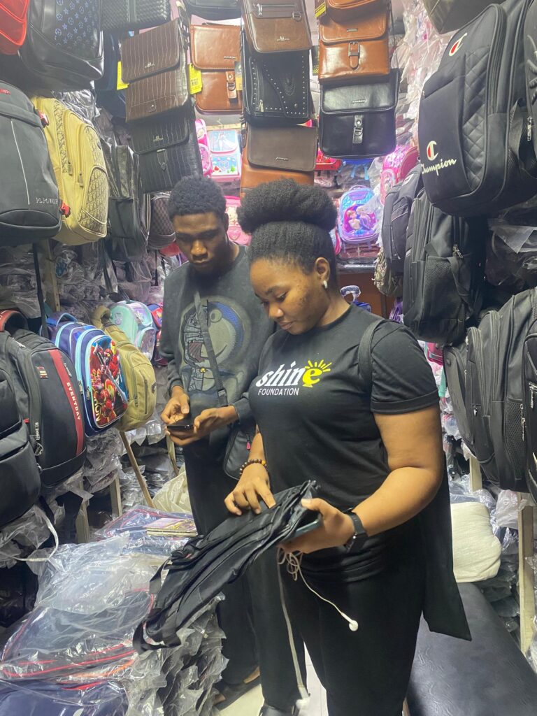 SHINE volunteers purchasing school bags at Eko Market, Lagos